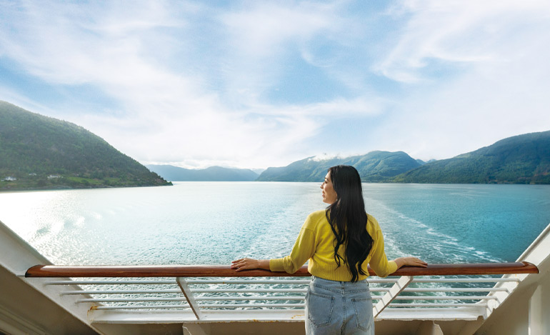 パシフィック・ワールド号はゆっくりとソグネフィヨルドを進む。ヨーロッパ本土で最長の204キロメートルにして最深(最も深い部分で1308メートル!) のフィヨルドがここにある。海に落ち込む急斜面を大きな滝が流れ、高くそびえる山の頂を白い雪が覆う。ノルウェージャン・ウッズ(ノルウェーの森) に包まれた峡谷を進む大型客船も、ここではまるで小舟のようにしか見えない。フィヨルドは息つく暇を与えない。次から次へと、海にいるとは思えぬような狭隘な水路が現れ、船の両側にごつごつとした岩肌が迫ってくる。