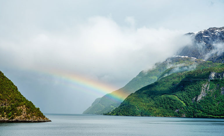 そしてフィヨルド沿いにある集落を形成するカラフルな家々に目を奪われた。これらのなかにはバイキング以前の時代にまでさかのぼる古い漁村も数多く点在するという。中世ヨーロッパ各地に進出し、その社会を現代にまで影響を与えるほどに大きく変えたバイキング。そのルーツを、これらの風景に見る思いがする。この日、フィヨルドの天候は雨、晴れ、そして雨と目まぐるしく変わった。しかしフィヨルドの奥深くでは青空が広がる。そして、雨上がりのフィヨルドには大きな虹がいくつもかかった。まるで、ここまで来た私たちへのご褒美のように。